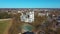 Aerial Shot of Birzai St. John the Baptist Church on the Southern Coast of the Lake Å irvÄ—na in Lithuania, Sunny Spring Day.